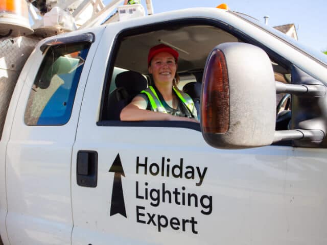 FestiLight employee in truck that says Holiday Lighting Expert