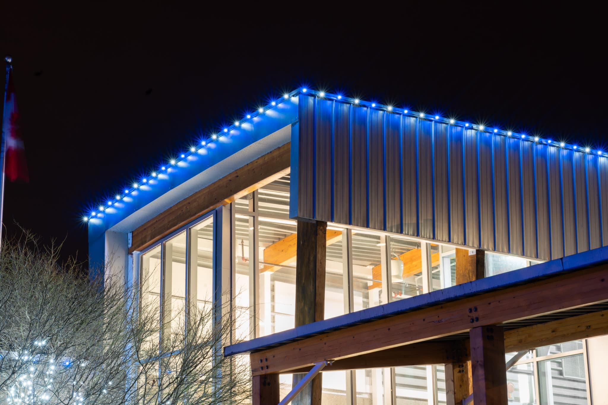 Blue and white coloured lights illuminate a commercial building at night.