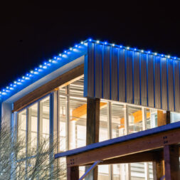 White and blue professional outdoor lighting illuminates a commercial building.