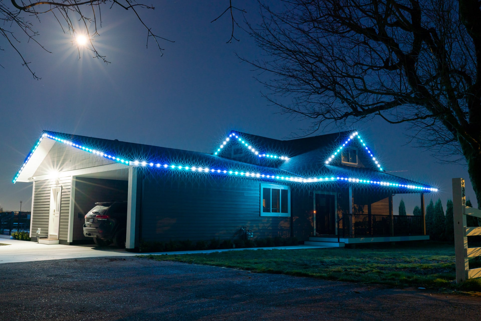 A house is lit up with Blue, white and green Chromaglow lights for permanent outdoor lighting