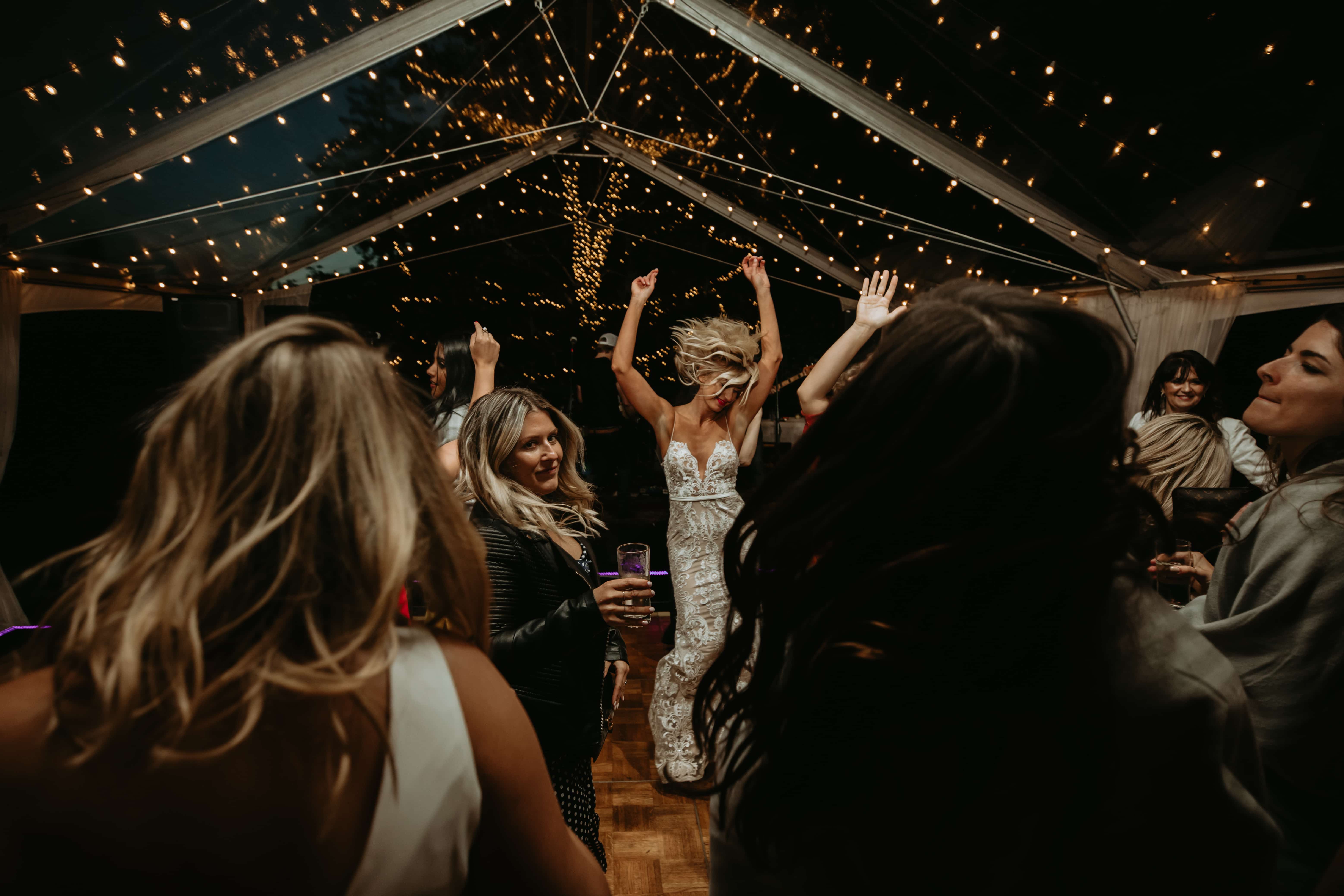 Fairy lights above wedding party reception with people dancing and enjoying lighting installation